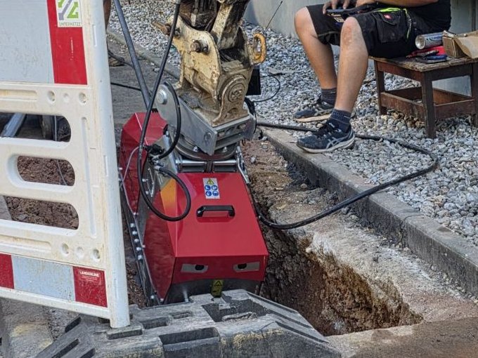 Mini-Spülbohranlage am Minibagger beim Bohren an einer Startgrube im Gehweg